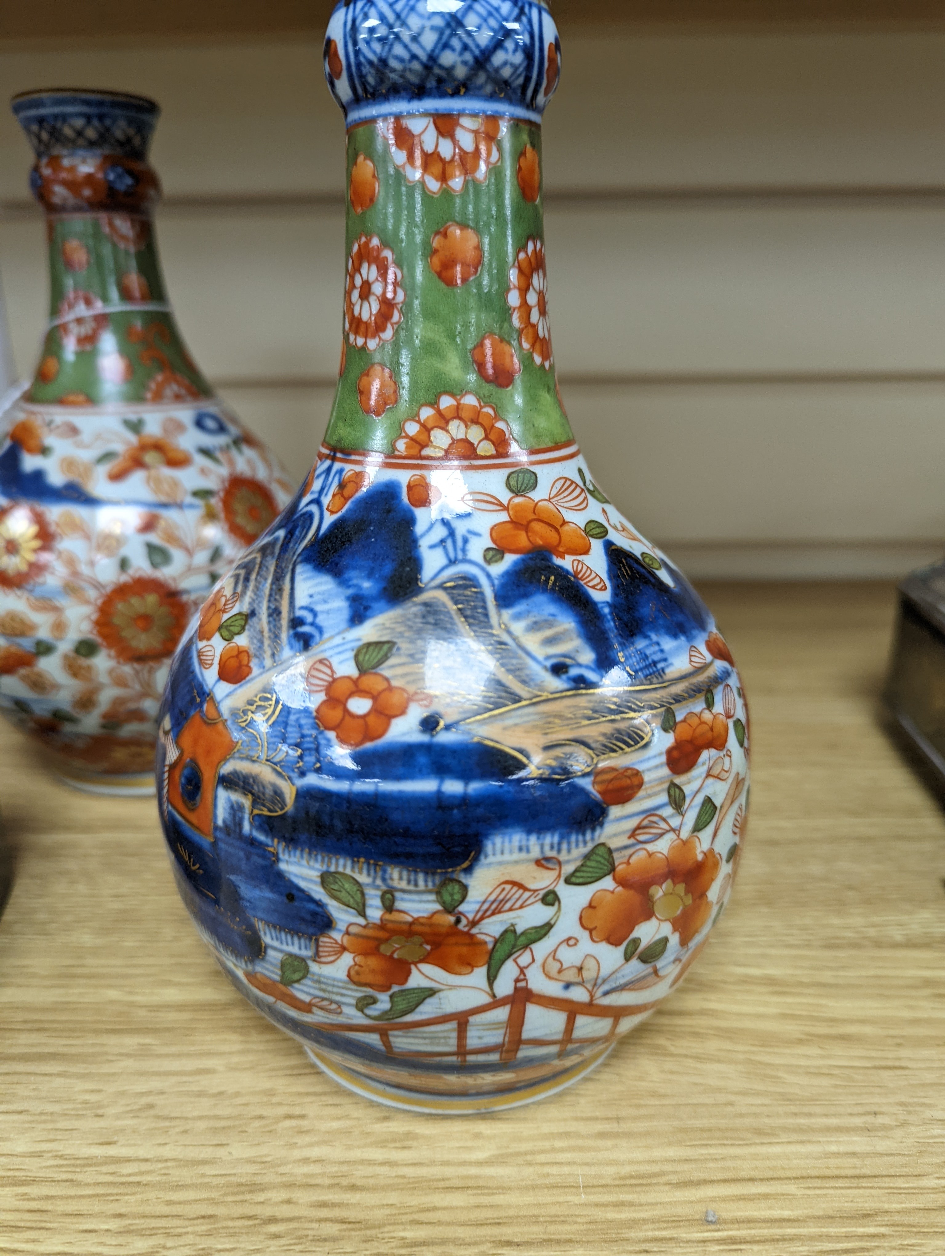 A pair of 18th century Chinese clobbered blue and white bottle vases 23cm
